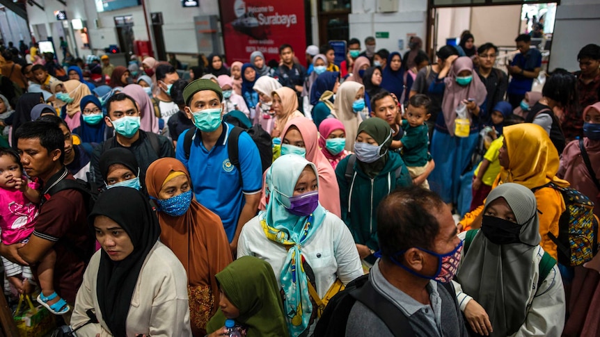 Passengers wearing facemasks while waiting to board a train in Surabaya, Indonesia.