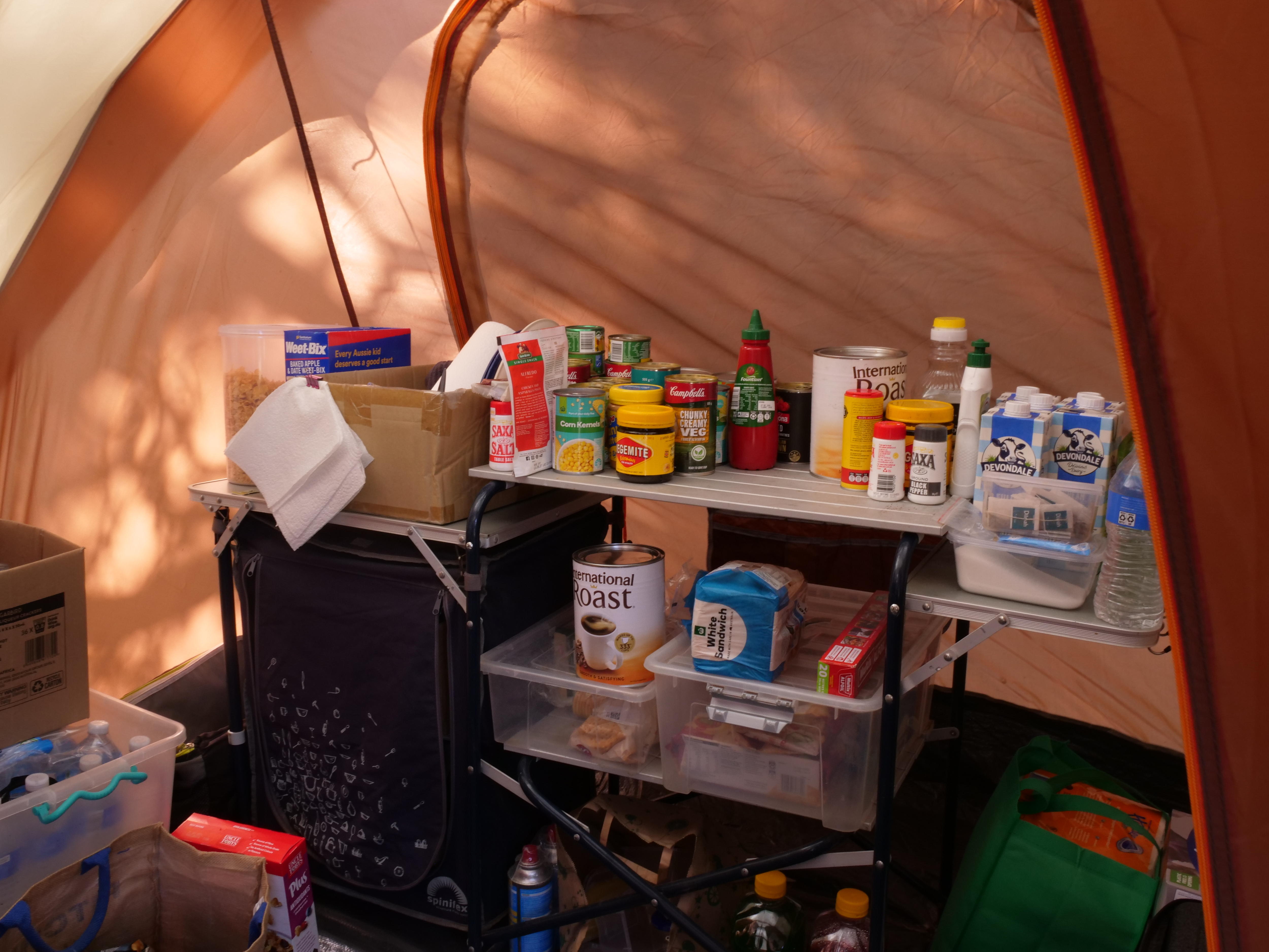 Una despensa llena de alimentos no perecederos en una tienda de campaña.