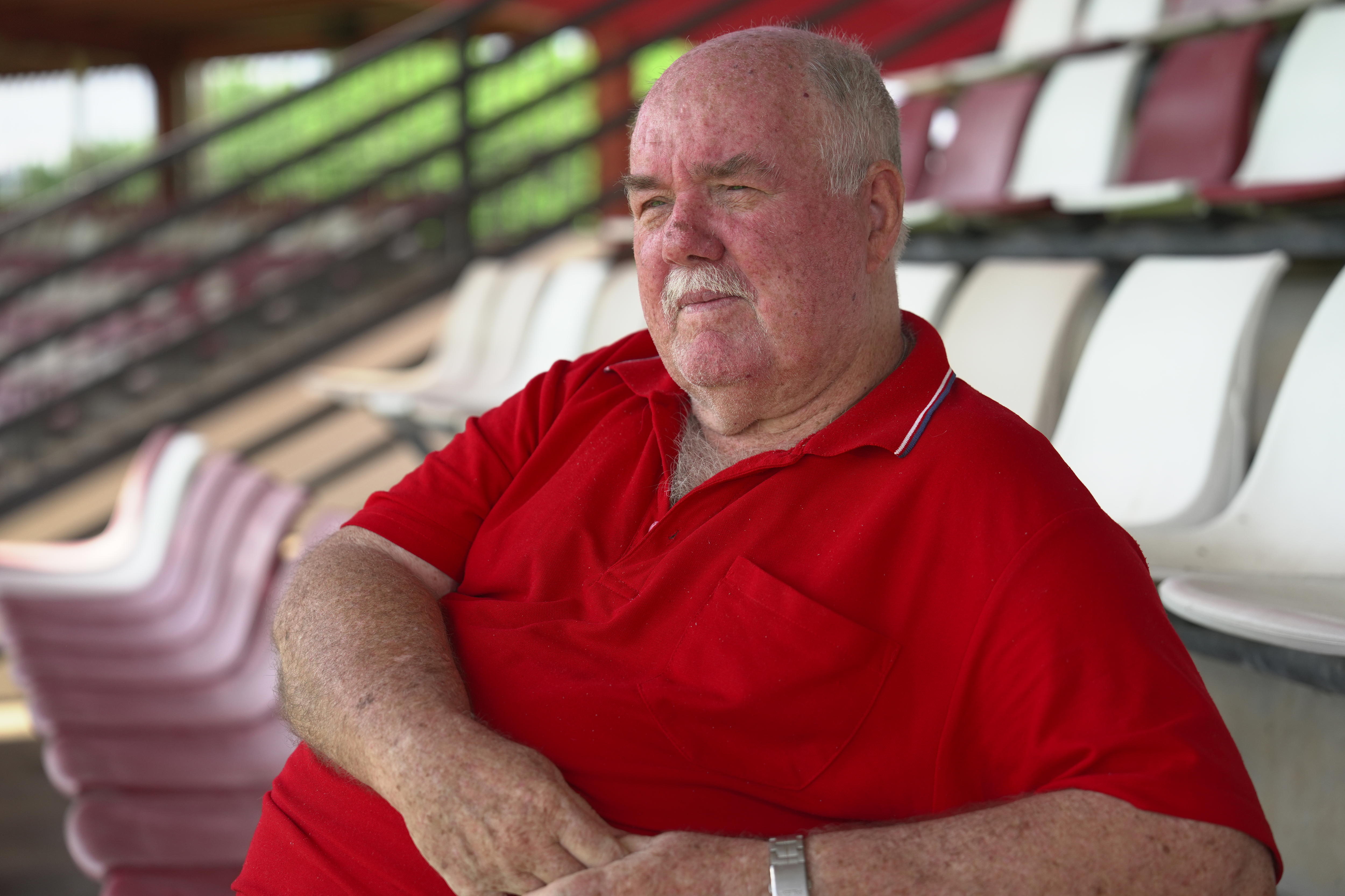 man in red shirt sits in sports grandstand