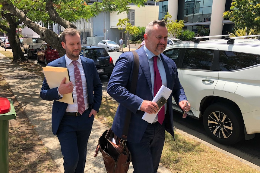 Brisbane-based criminal lawyer, Adam Magill (right), walking from Southport Magistrates Court.