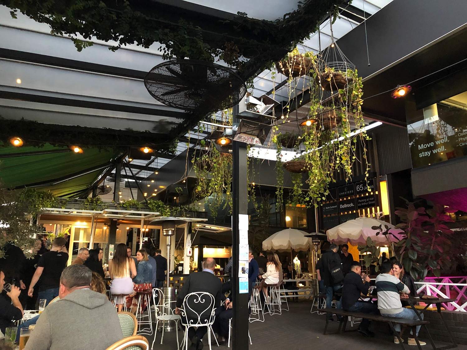 La gente bebe en los bares en un área cubierta al aire libre.