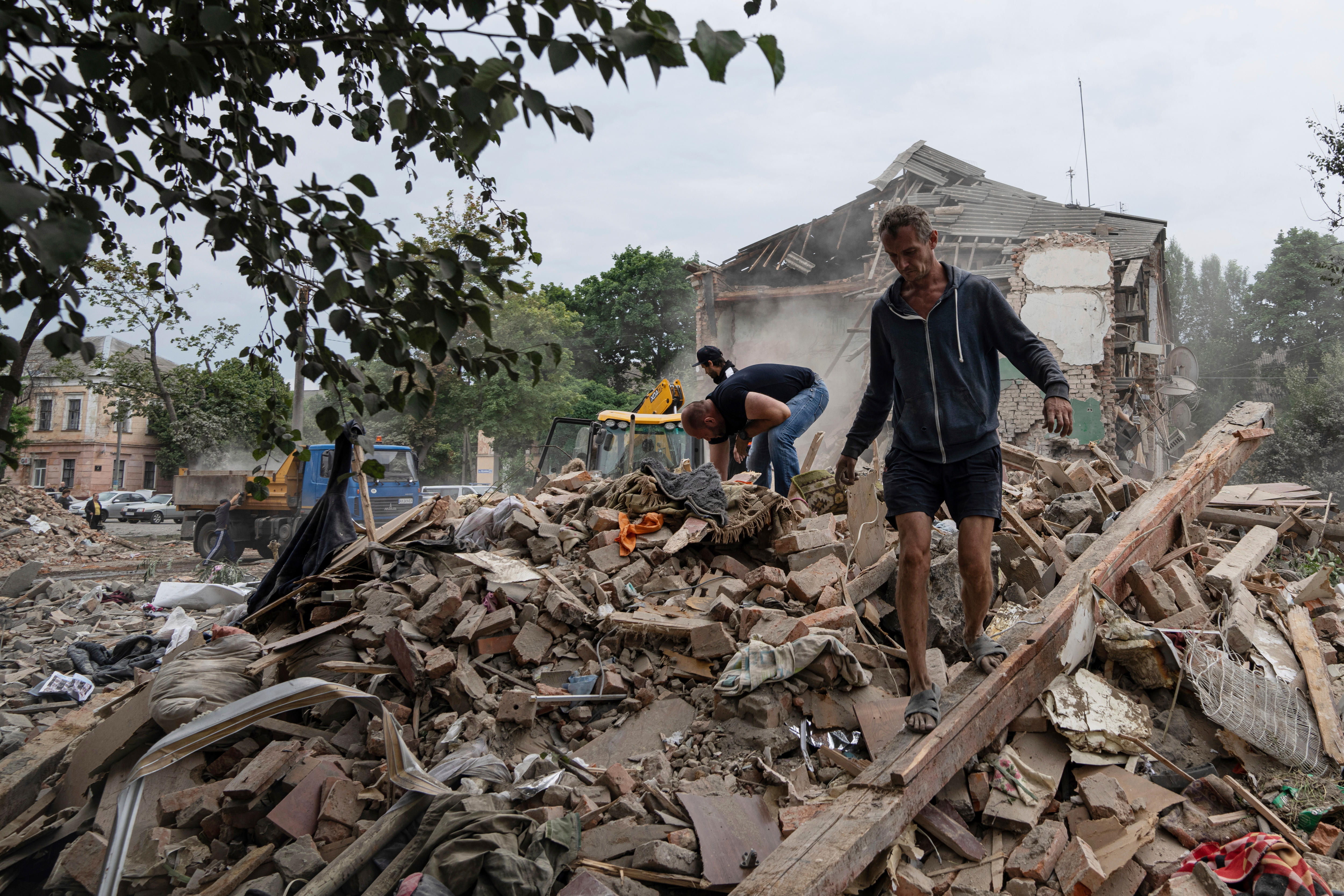 People search through the rubble of a destroyed building.