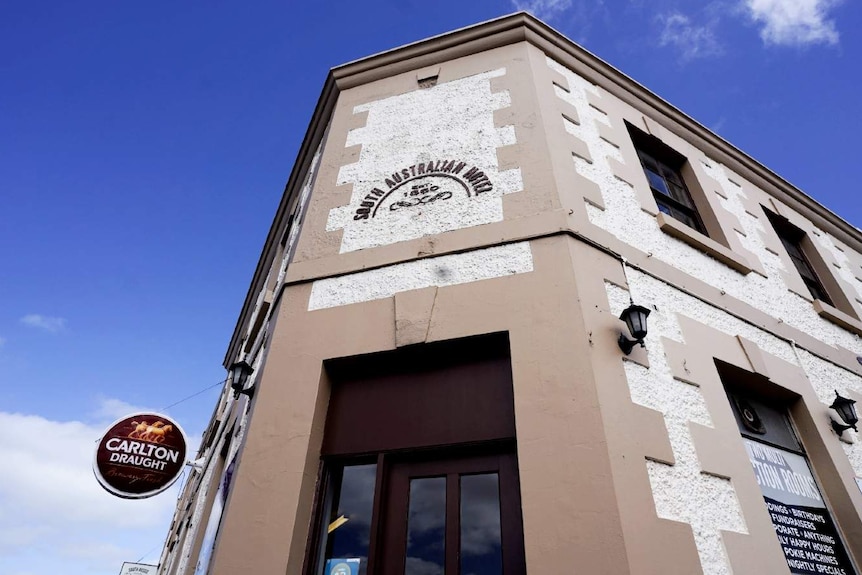 A large two-storey colonial building with a sign on it reading 'South Australian Hotel Established 1860'.