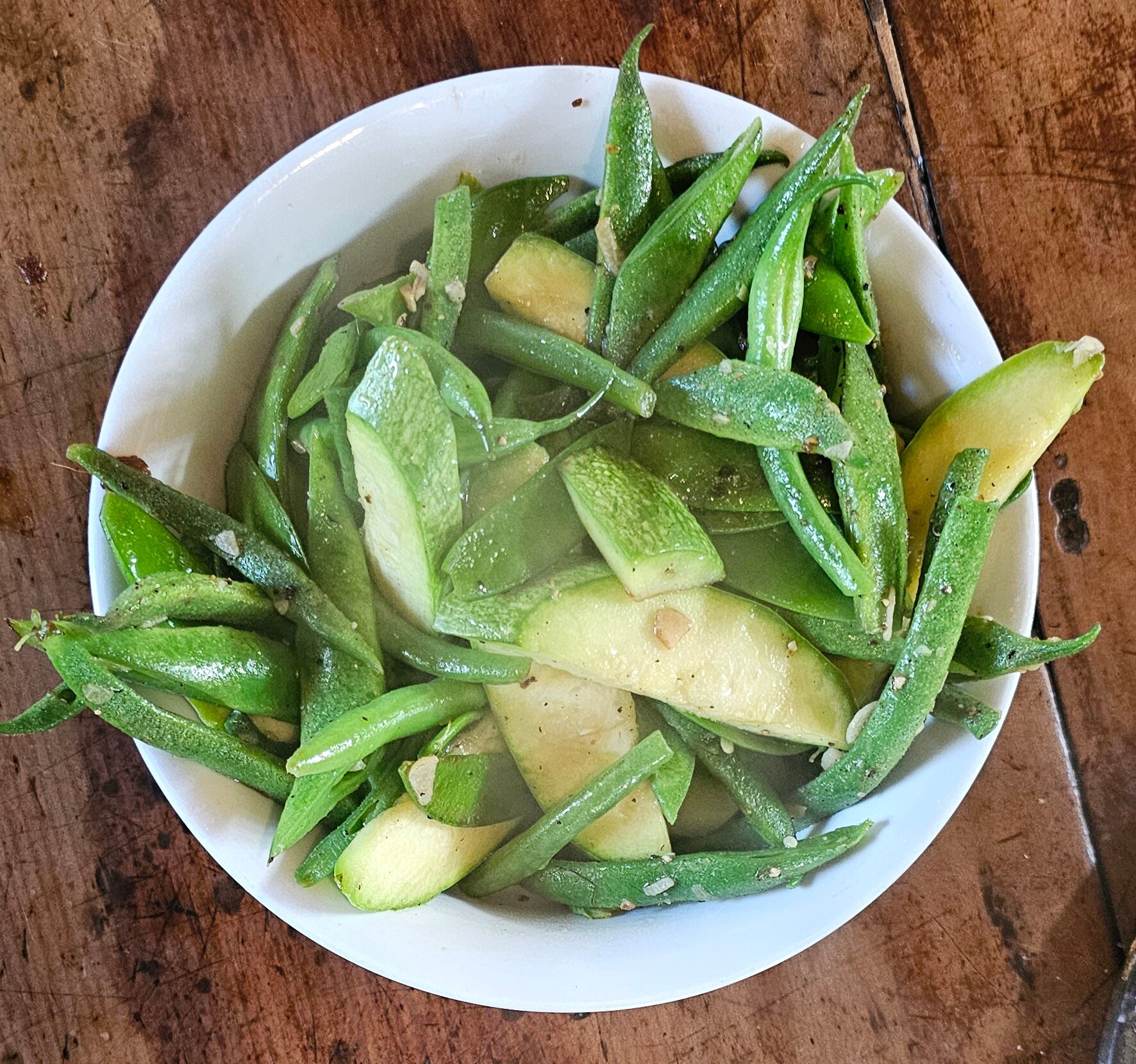 Green salad in bowl with zucchini's, orange, beans