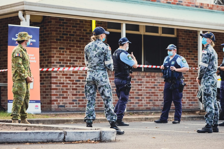 army and police officers standing outside a building