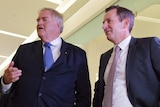 Former federal opposition leader Kim Beazley and WA Opposition leader Mark McGowan stand talking wearing suits.