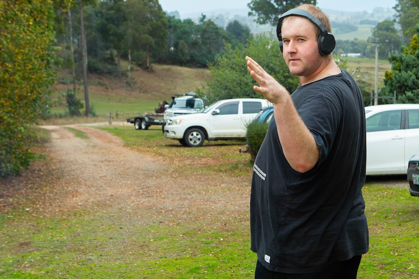 Austin turns to wave, wearing headphones for his beloved music.