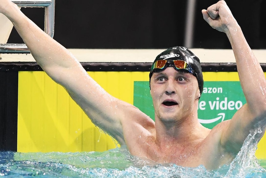 A man in a pool celebrating 