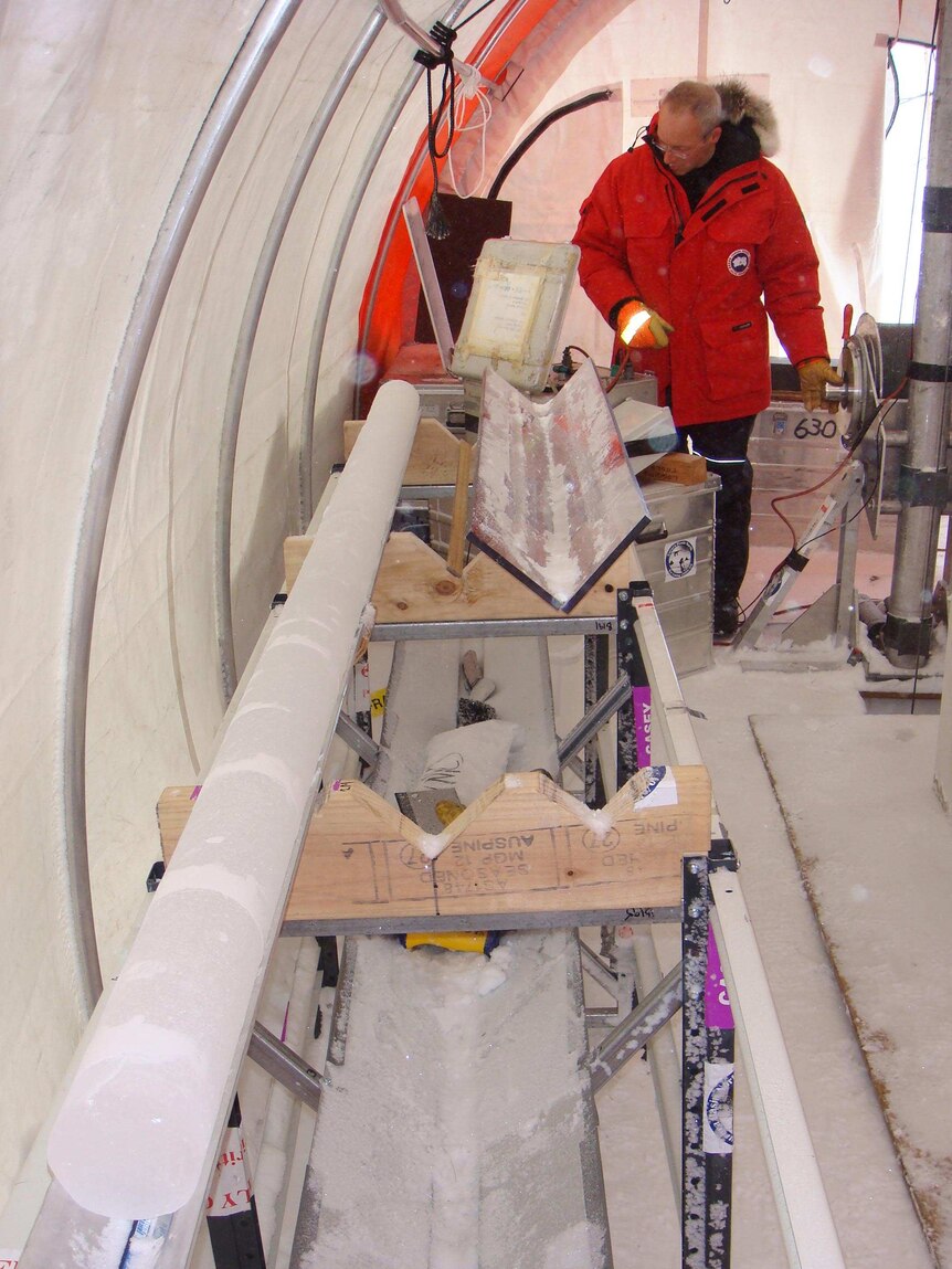 Dr Tas van Ommen stands next to an ice core at the Law Dome ice core drill camp, Antarctica.