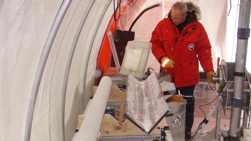 Dr Tas van Ommen stands next to an ice core at the Law Dome ice core drill camp, Antarctica.