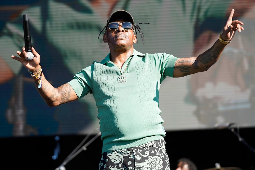 Coolio performs on stage in a green shirt