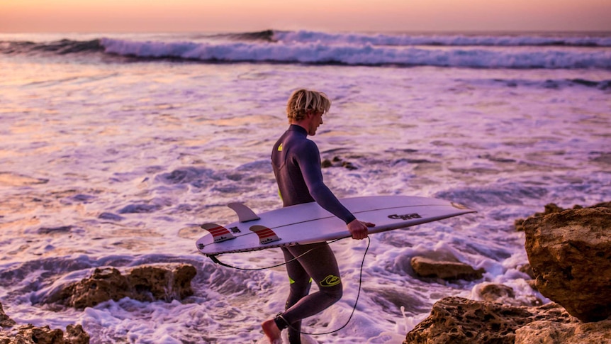 Surfer Cody Robinson hits the waves at Bells Beach at dawn.