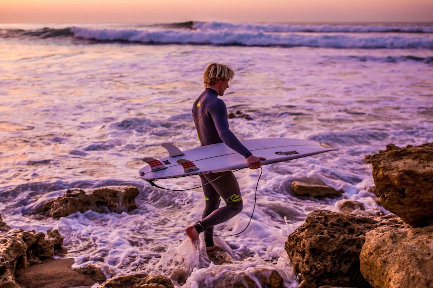 Surfer Cody Robinson hits the waves at Bells Beach at dawn.