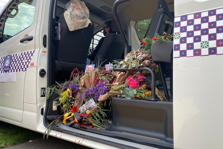 Memorial photos and flowers in a mock prison van