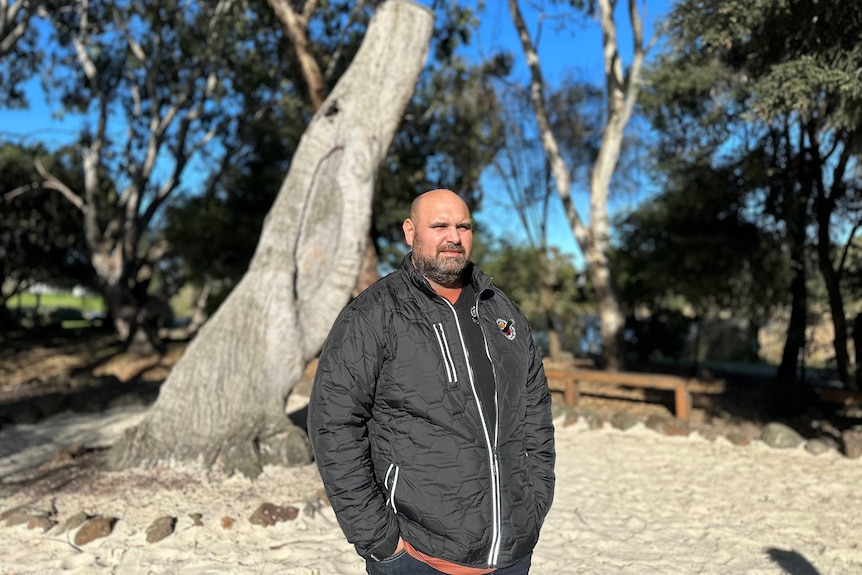 Simon Flagg standing in front of a tree.