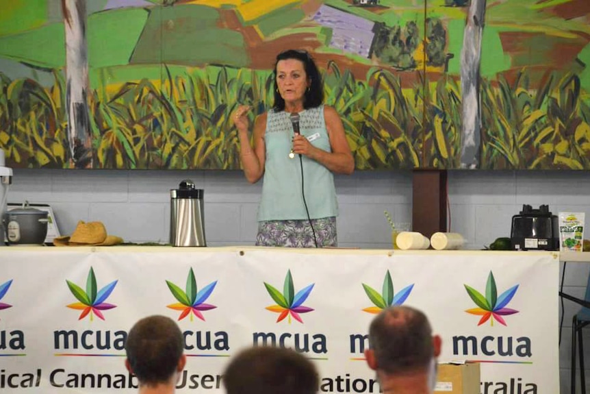 A woman standing at a podium speaking into a microphone