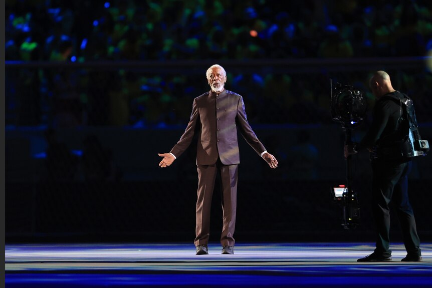 Morgan Freeman stands with his arms akimbo at the FIFA World Cup opening ceremony.