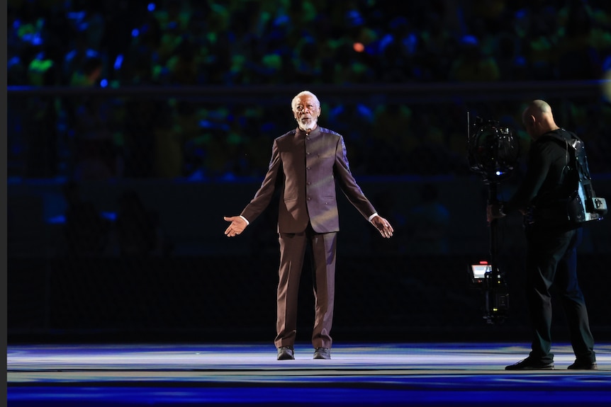 Morgan Freeman stands with his hands akimbo at the opening ceremony of the FIFA World Cup.