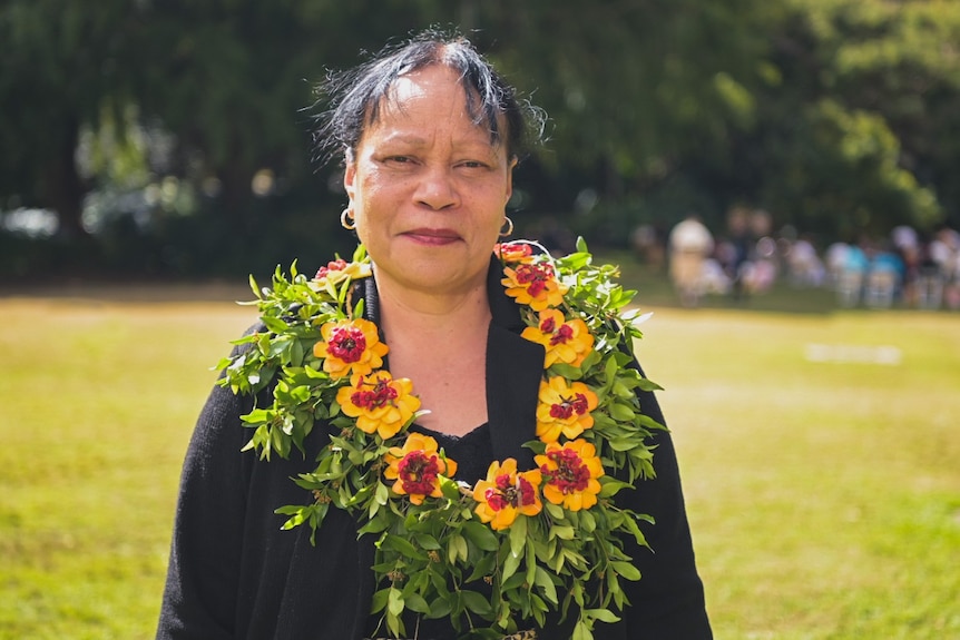 Pasemata Vi Taumisila stands in a field with a flower necklace.