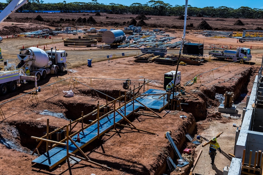 Construction workers and a cement truck on the site of a rare earths refinery.  