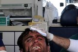 A wounded Libyan rebel points to the camera as he is treated near Ajdabiya on March 25, 2011.