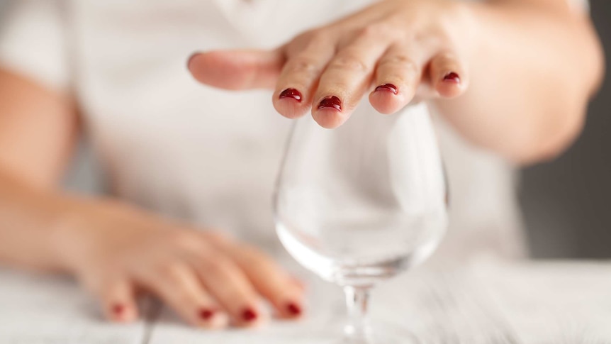 Woman putting hand over an empty wine glass