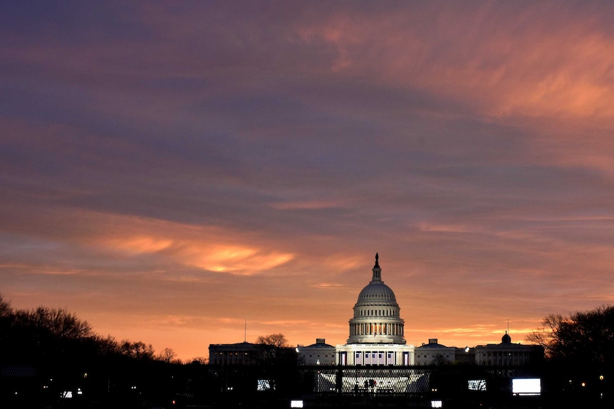 The sun rises over the US Capitol on the National Mall