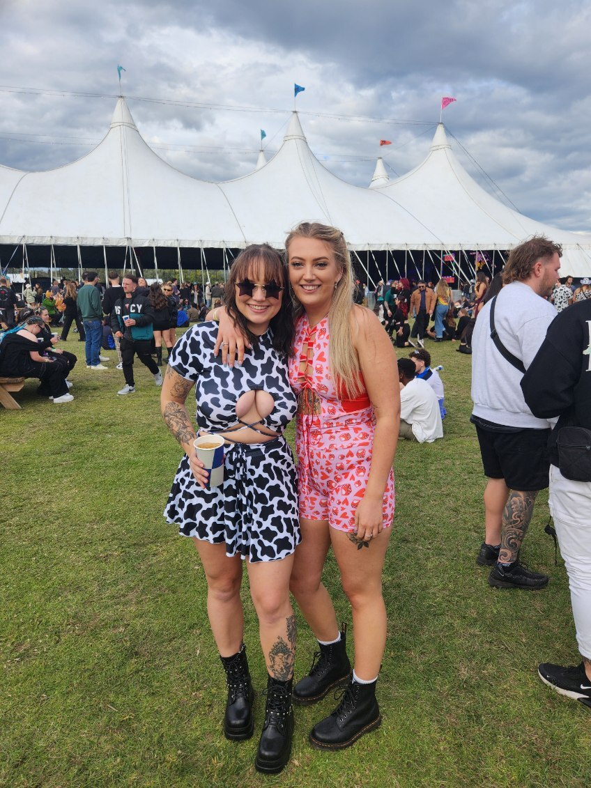 Two woman at music festival embracing