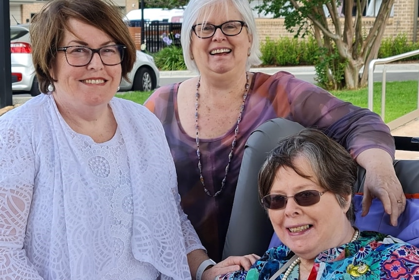 Three women taking a photo together. 