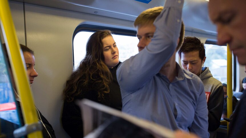 Student Molly Willmott stands on a crowded Melbourne train to get to university.