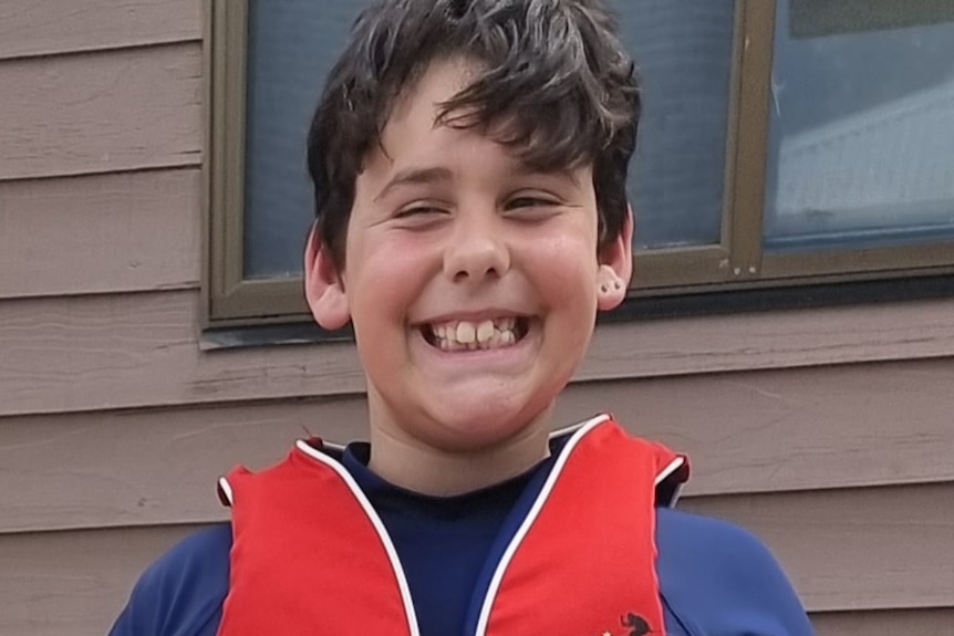 Grinning boy with black hair in life vest