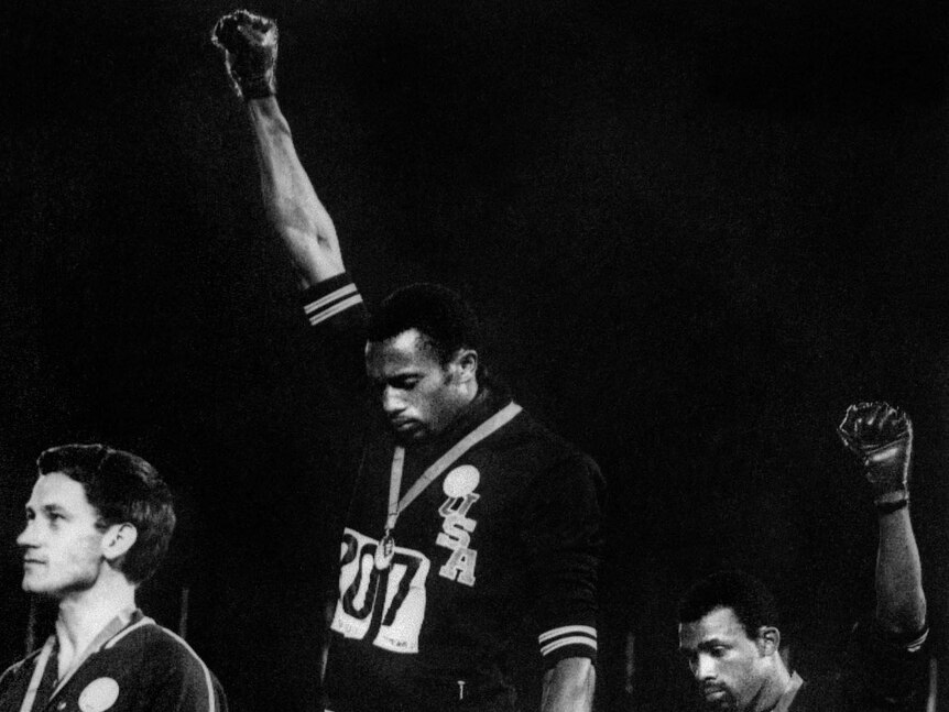 Tommie Smith (C) and John Carlos (R) raise their gloved fists