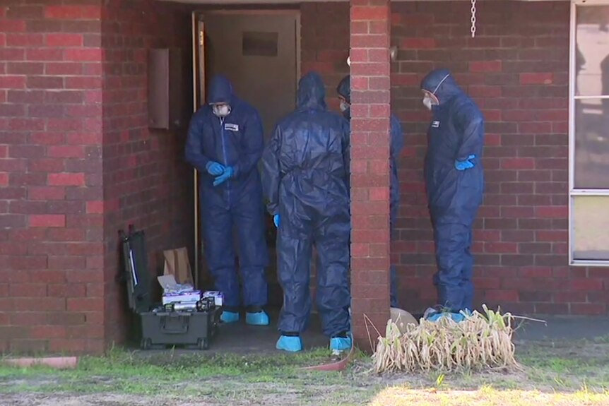 A group of four WA Police forensics officers stand at the front of a red brick house wearing blue jumpsuits.