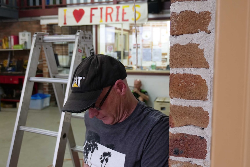 A man bows his head to remember fallen firefighters at the St Albans RFS.