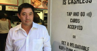 Marcus Chang in front of Spice Alley's cashless sign