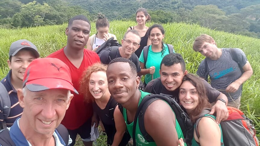 A selfie showing a group of tourists in a lush mountainous area.