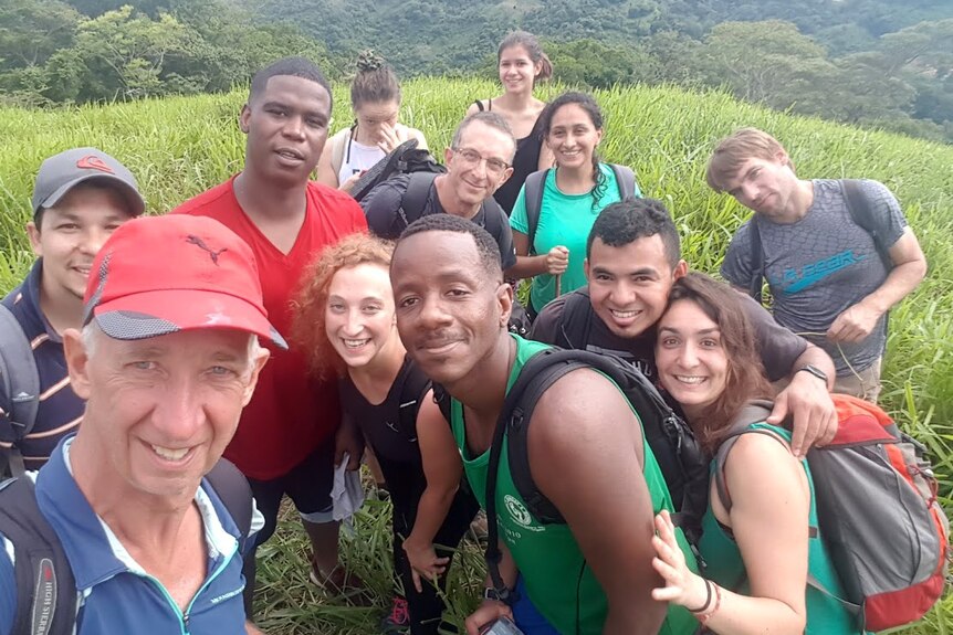 A selfie showing a group of tourists in a lush mountainous area.