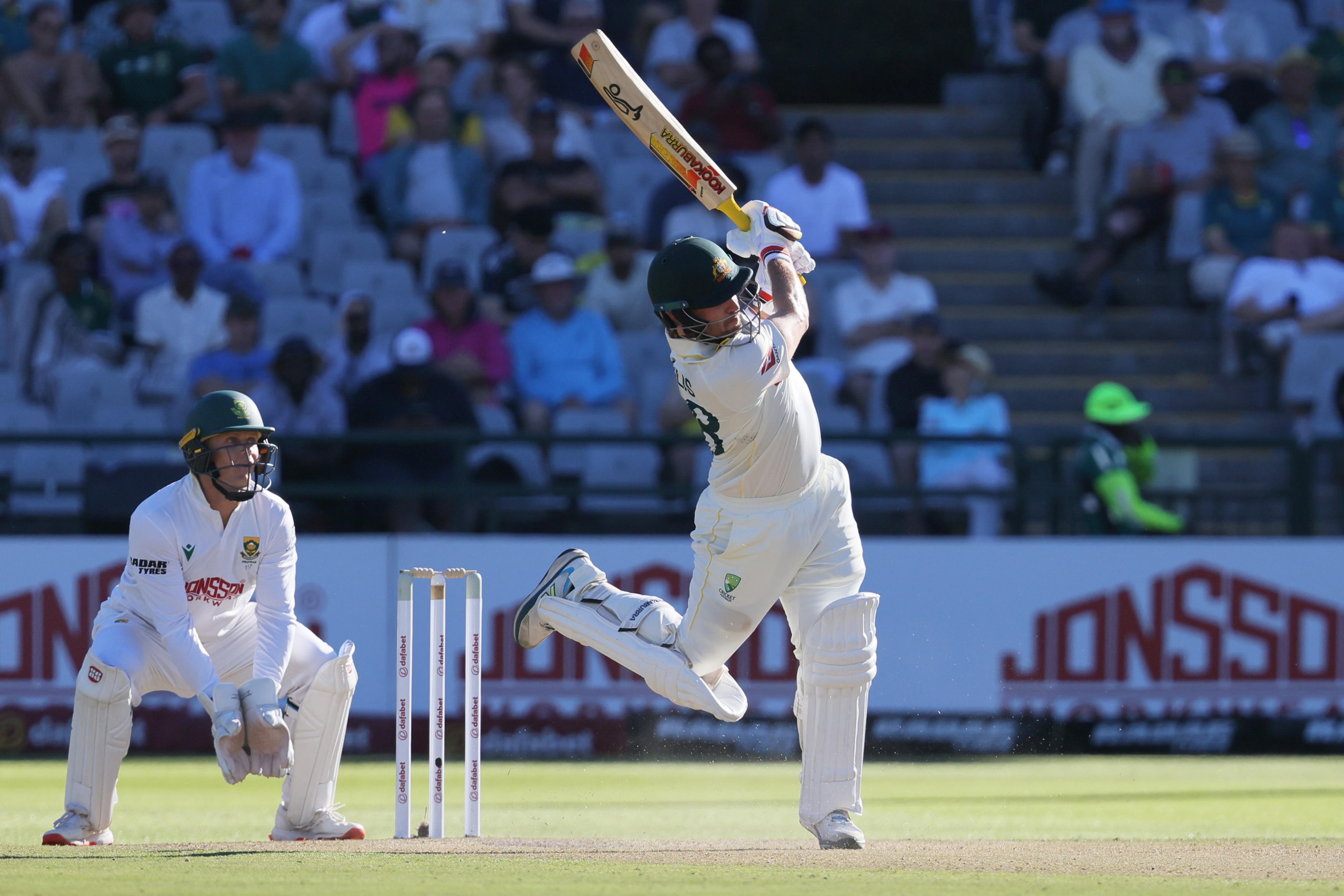 Australia batter Josh Inglis plays a flourishing cricket shot with one leg in the air.