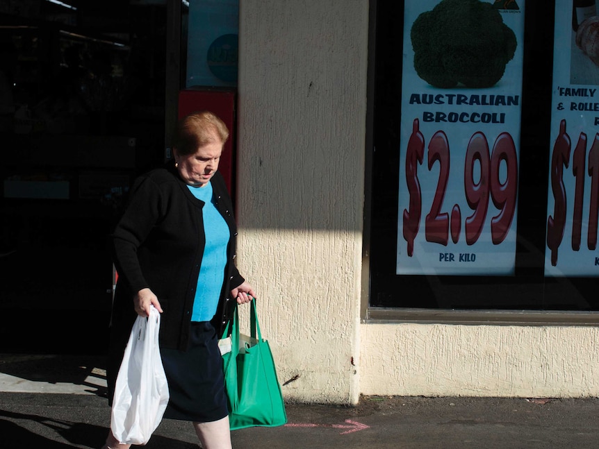 A customer leaves Piedimonte's Supermarket holding two bags of groceries