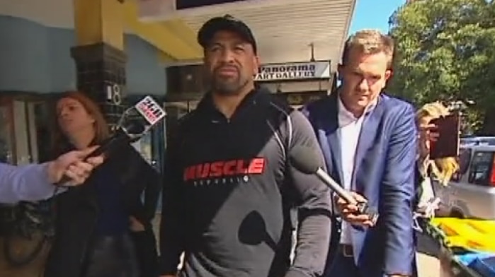 Former NRL player John Hopoate walking along a street after leaving Manly Local Court.