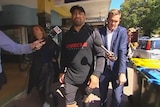 Former NRL player John Hopoate walking along a street after leaving Manly Local Court.