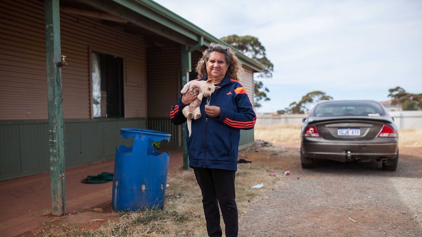 Ninga Mia local woman Elizabeth outside her home with her pet dog.