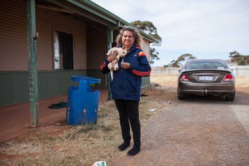 Ninga Mia local woman Elizabeth outside her home with her pet dog.