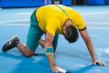 Australian tennis star Nick Kyrgios on his hands and knees during a match at the ATP Cup.