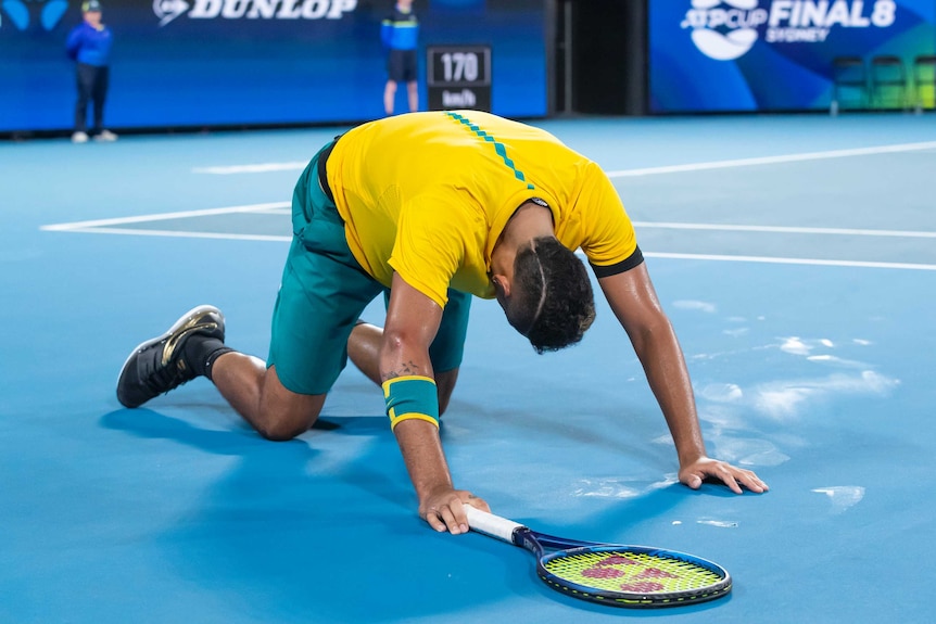 Australian tennis star Nick Kyrgios on his hands and knees during a match at the ATP Cup.