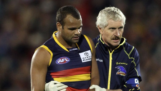 Return date unknown...Graham Johncock is helped from the field during the Crows' win.