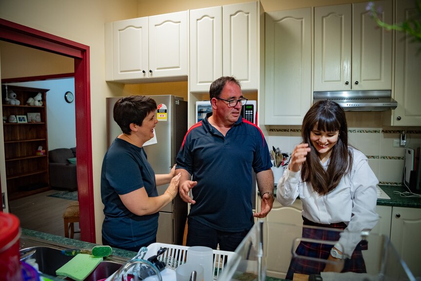 Nicola and her husband Scott joke with their daughter Charlotte in the kitchen of their home in Castle Hill