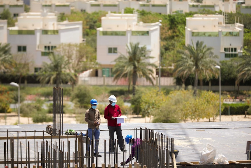 Construction workers on a roof in a desert locale