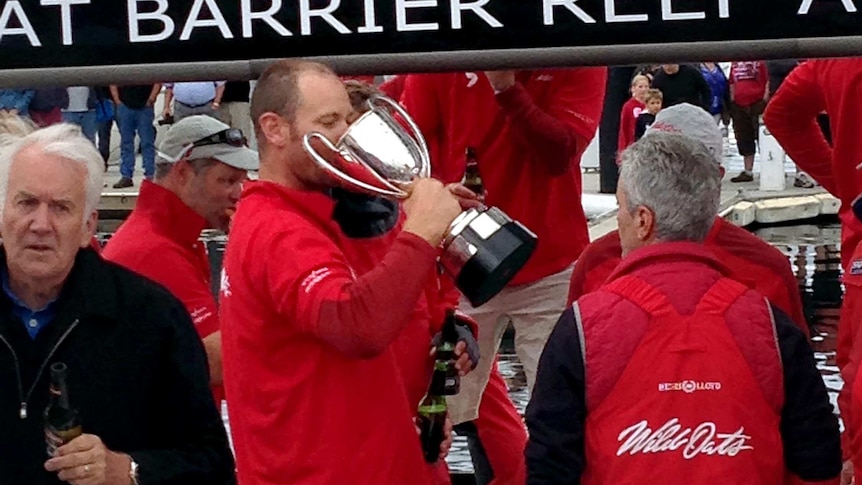 Wild Oats XI crew member drinks from the cup after the yacht won the Sydney to Hobart..