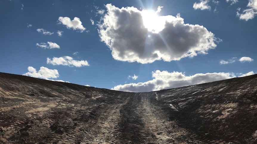 The camera pans up out of an excavated dam